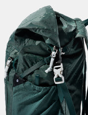 Green backpack with water droplets on a white background