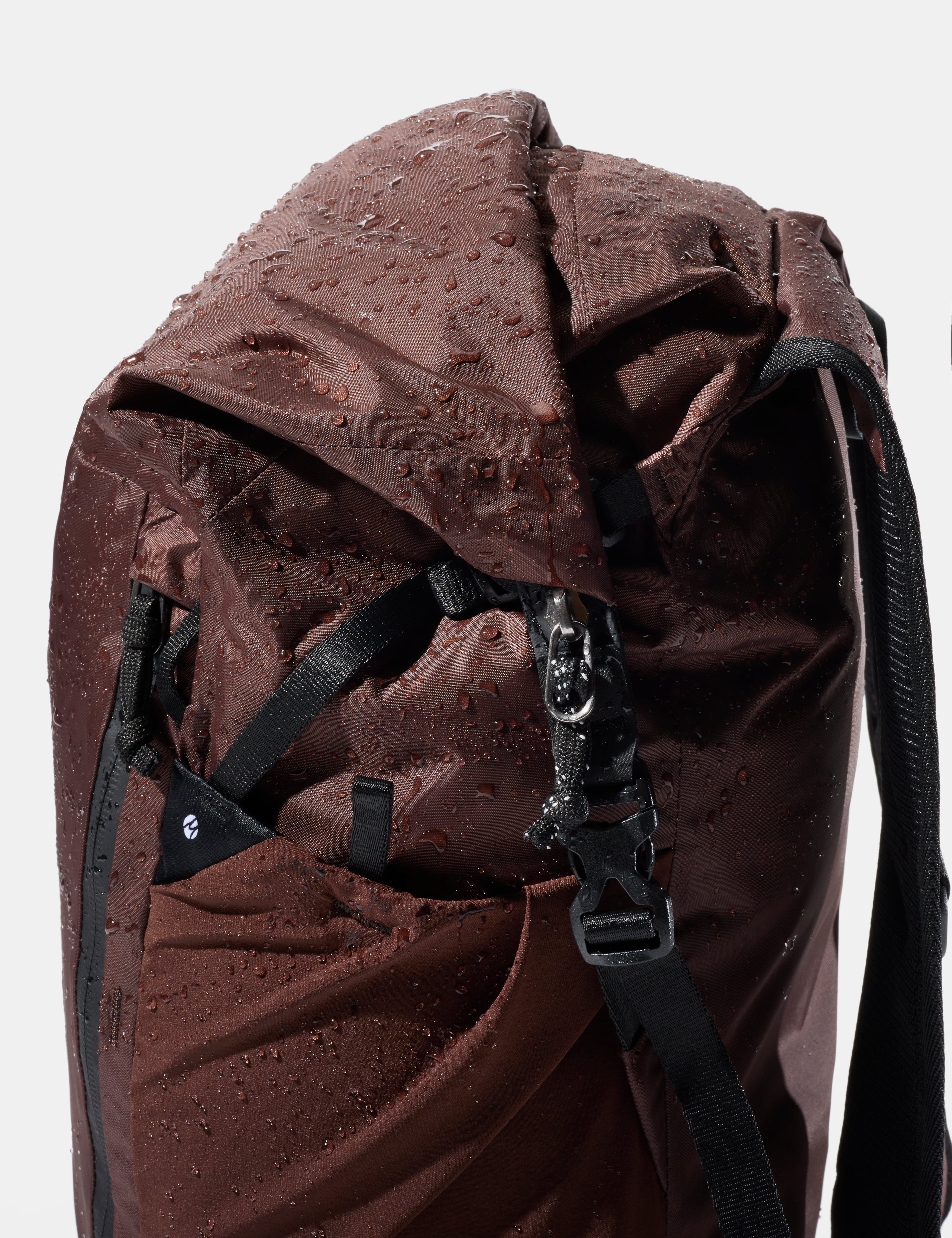garnet waterproof backpack with black straps and water droplets on a white background