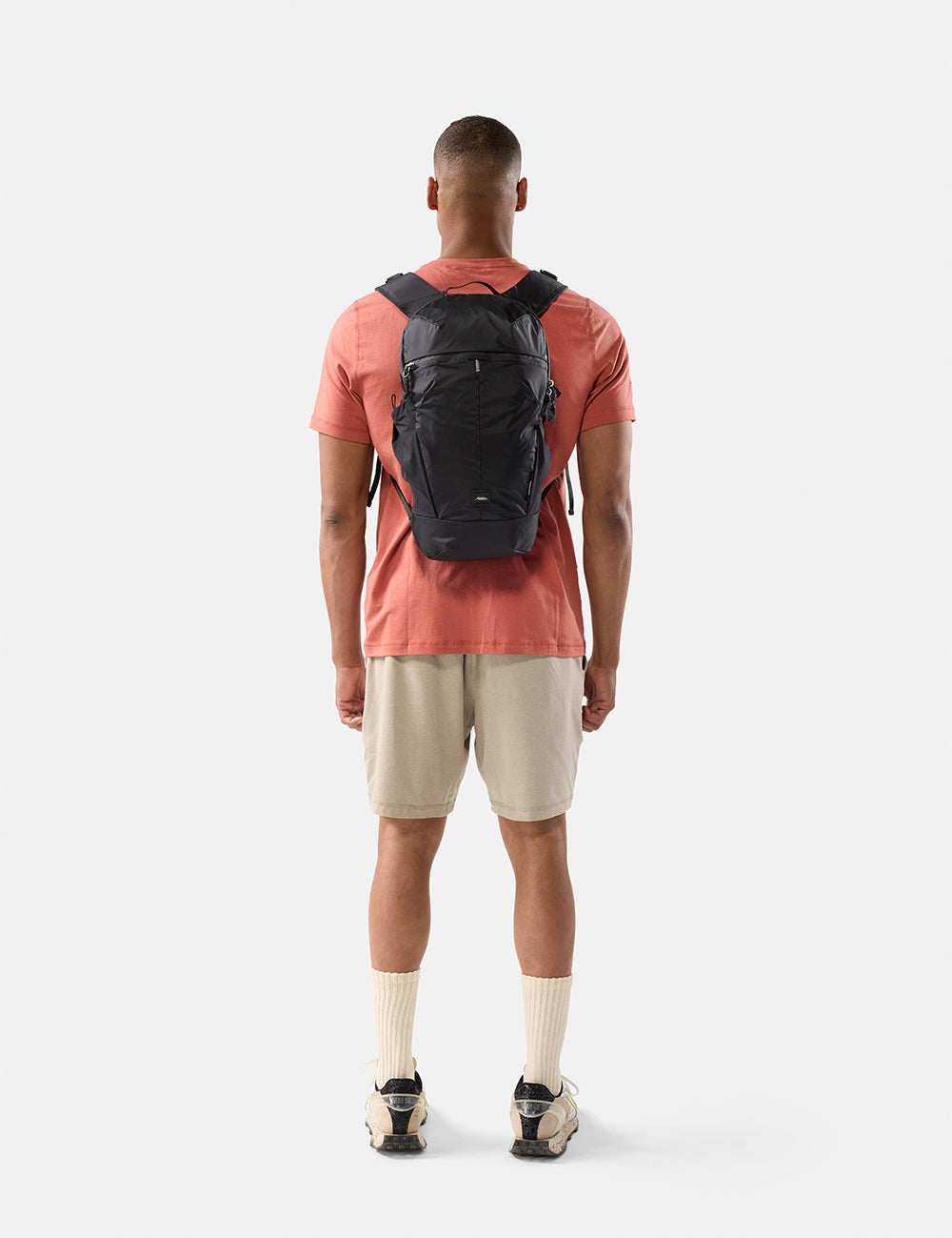 Man wearing a black backpack on a white background