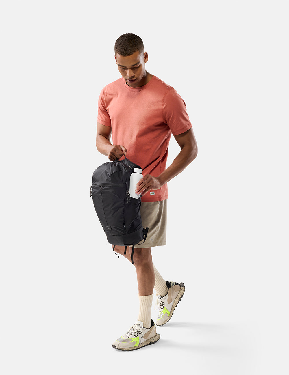 Man holding a black bag on a white background