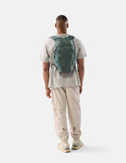 Person wearing a green backpack on a white background