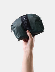 Hand holding a juniper travel pack with a visible brand label on a light gray background