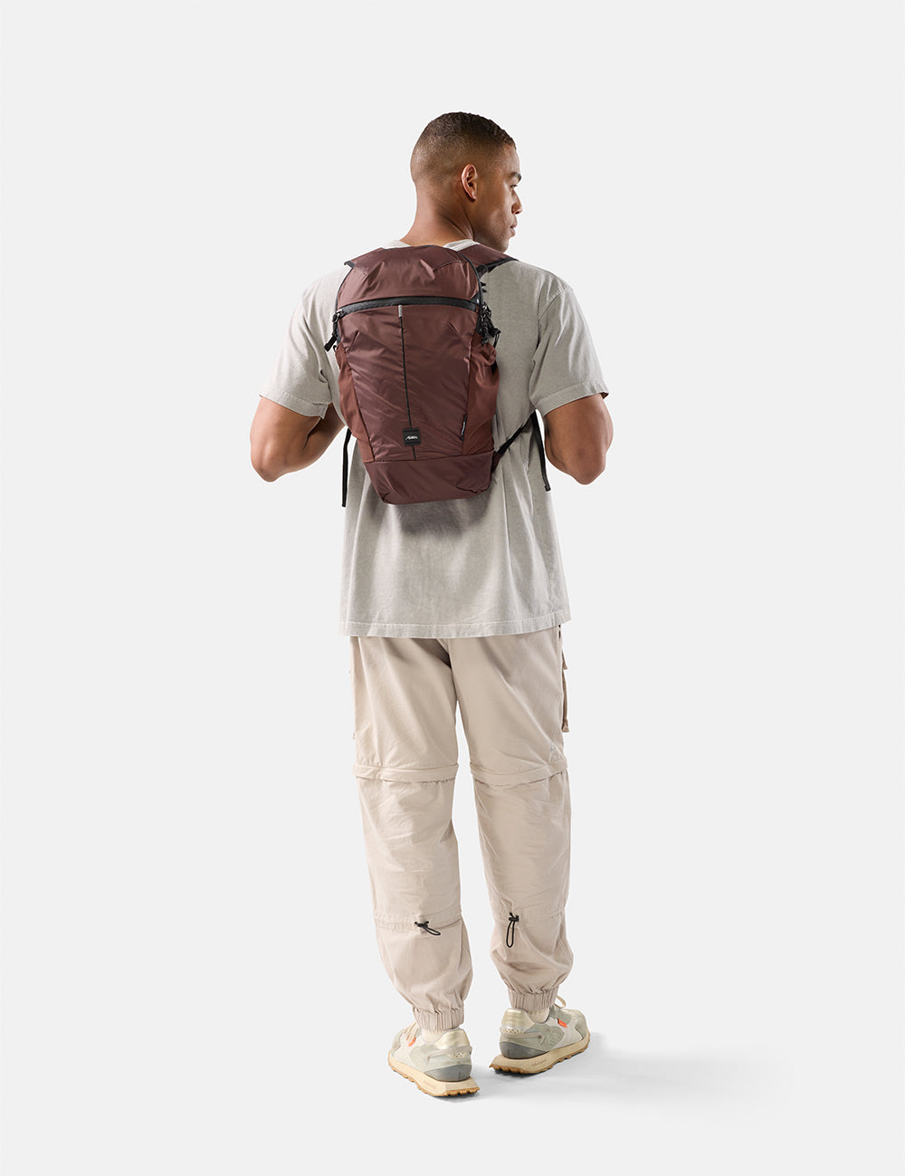 Man wearing a garnet backpack on a white background