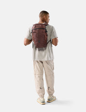 Man wearing a garnet backpack on a white background