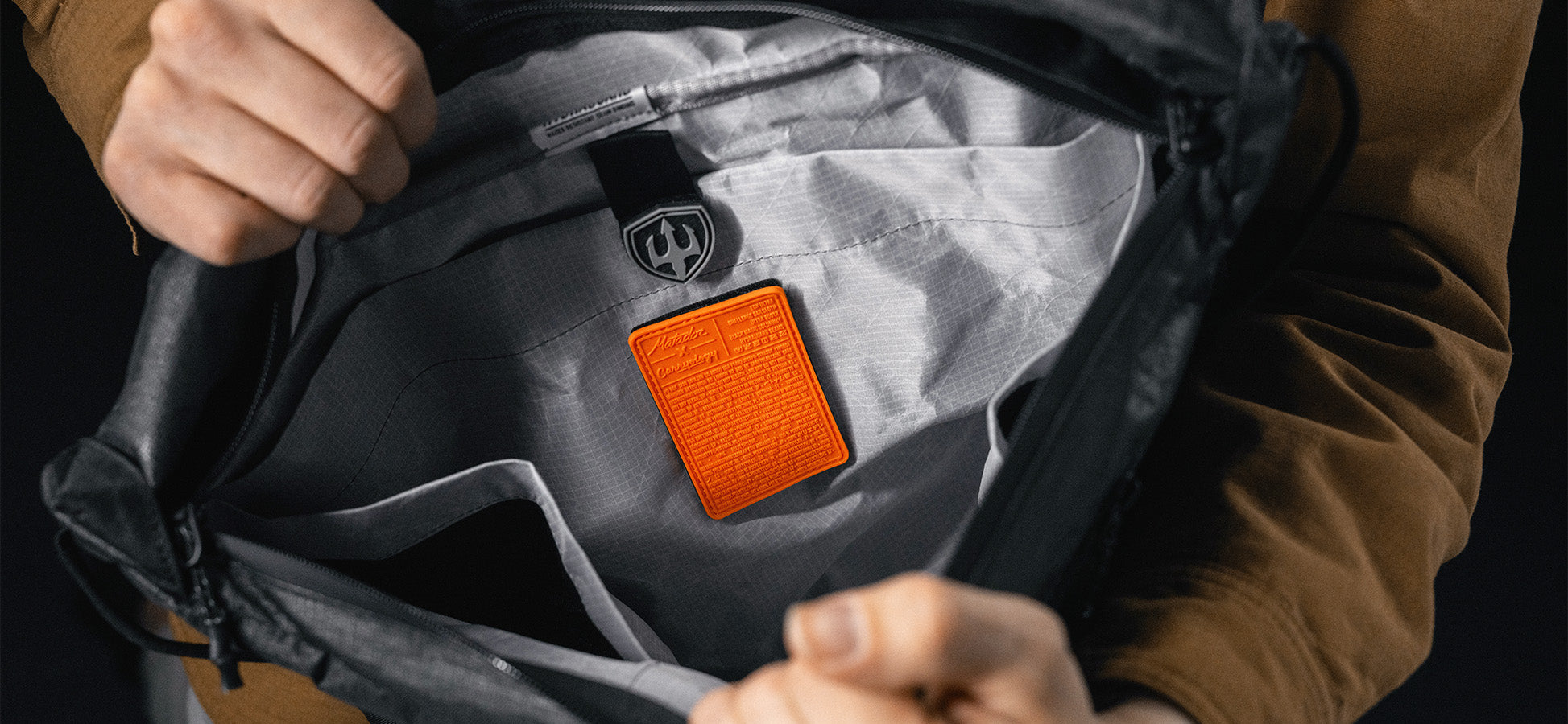 interior view of black messenger bag, showing orange patch