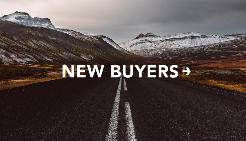 Shot down road of dramatic snowy mountain scape with text: New Buyers
