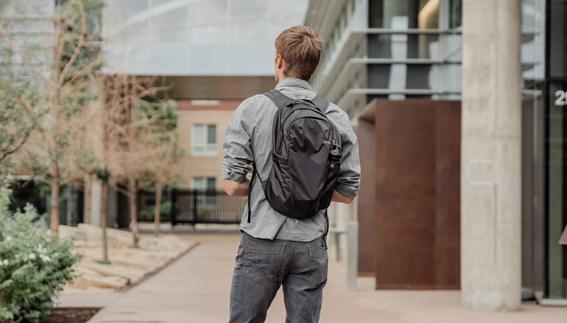 Man in city, wearing On-Grid Backpack