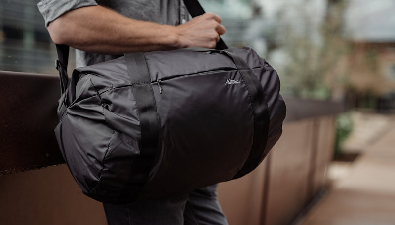 Man in city with On-Grid Duffle slung across his body