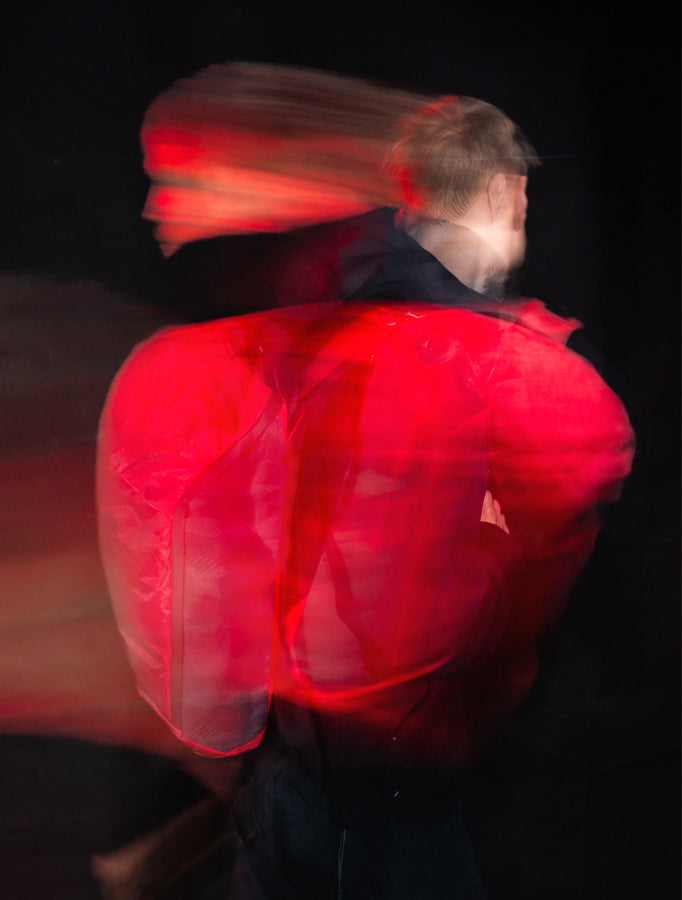 blurred motion image of man with streaks of red and black
