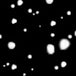 A black background with scattered irregular white spots, resembling a high-contrast abstract pattern or close-up of a textured surface.