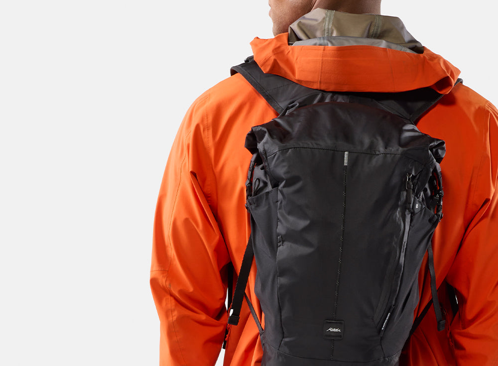 person in orange jacket wearing orange backpack