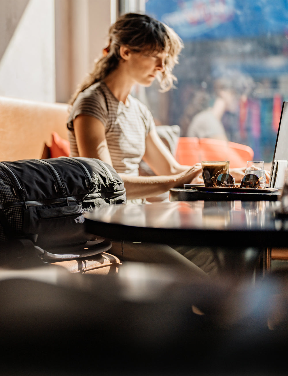 Woman working in sunny coffee shop window