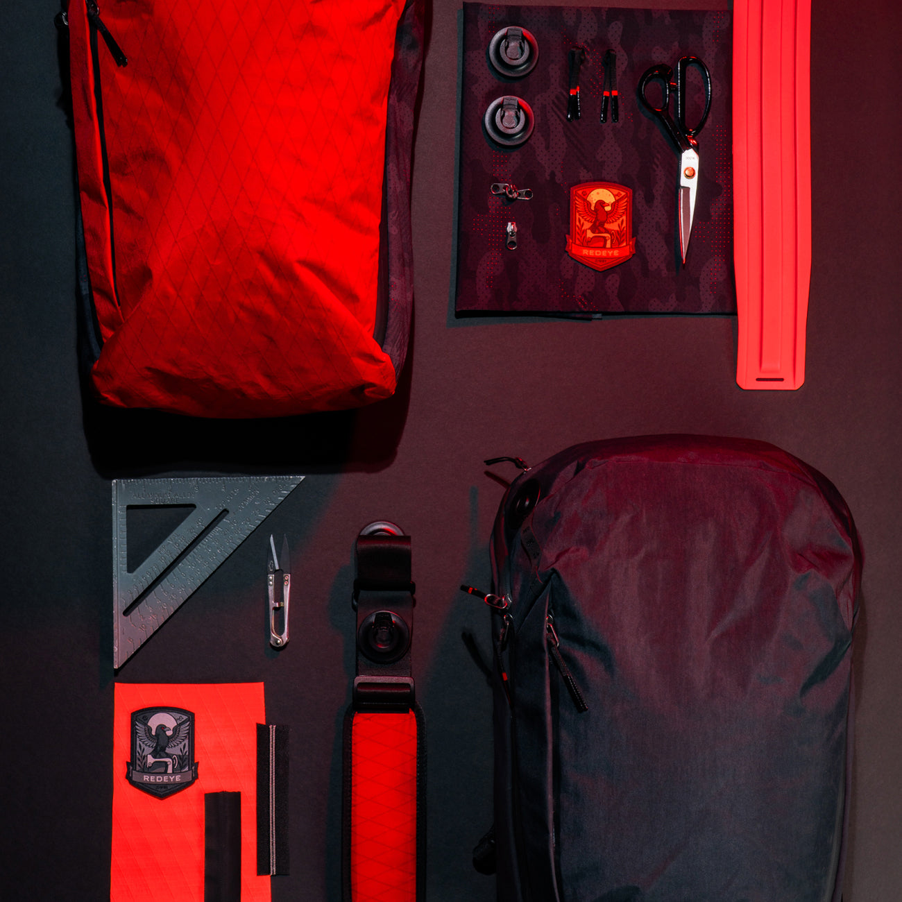 backpacks and design supplies on black background