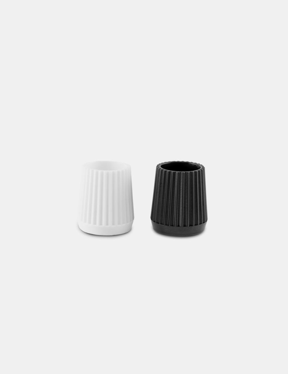 two toothpaste tube lids, black and white