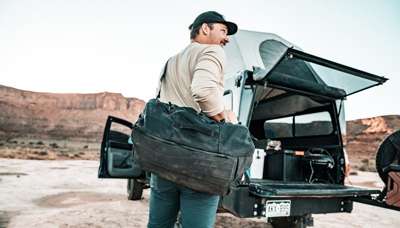 Man next to truck in desert canyon, wearing SEG45 as a cross body duffle