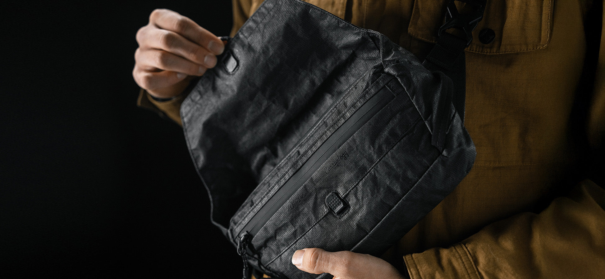 close up view of man opening black sling bag