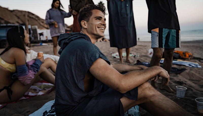 Man on beach with friends, wearing Charcoal Towel Poncho