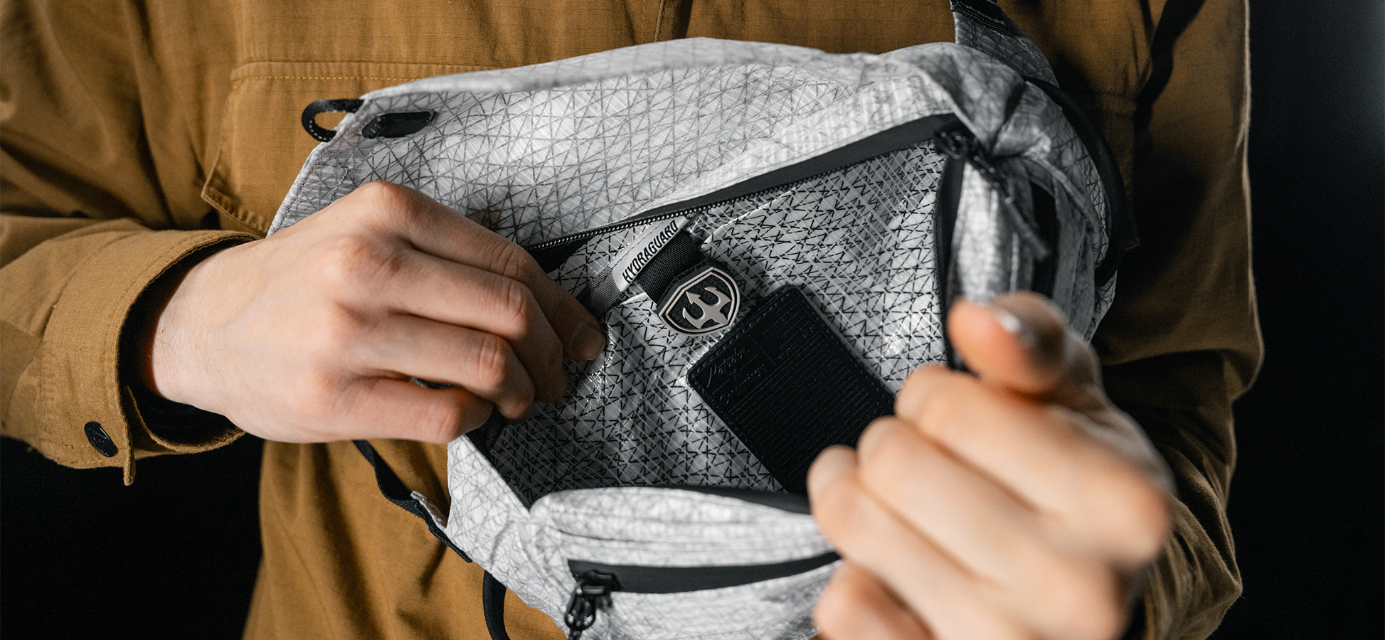 close up view of man opening white sling bag