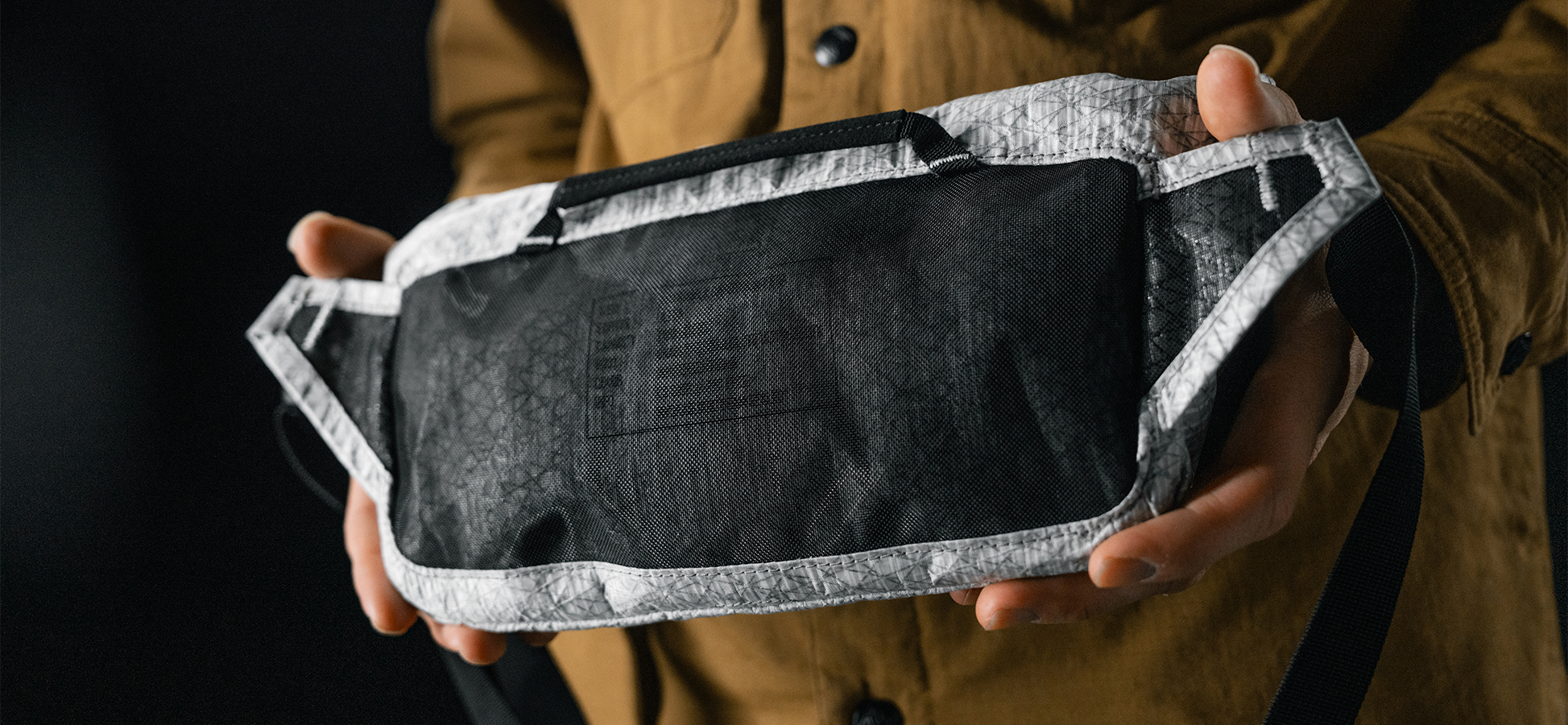 detail view of mesh material on back of white sling bag