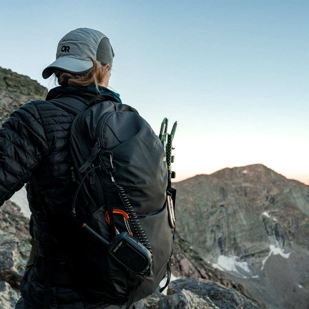 woman on rocky terrain wearing black backpack