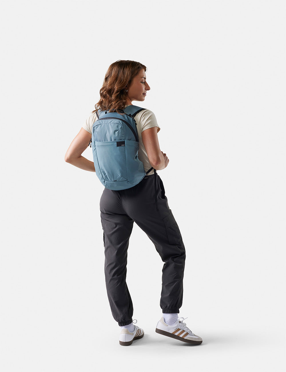 woman wearing a blue backpack in athleisure outfit