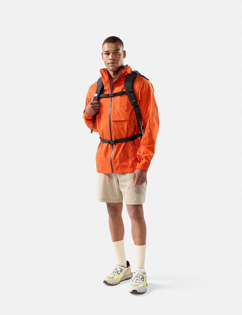 video of man in orange jacket wearing black backpack