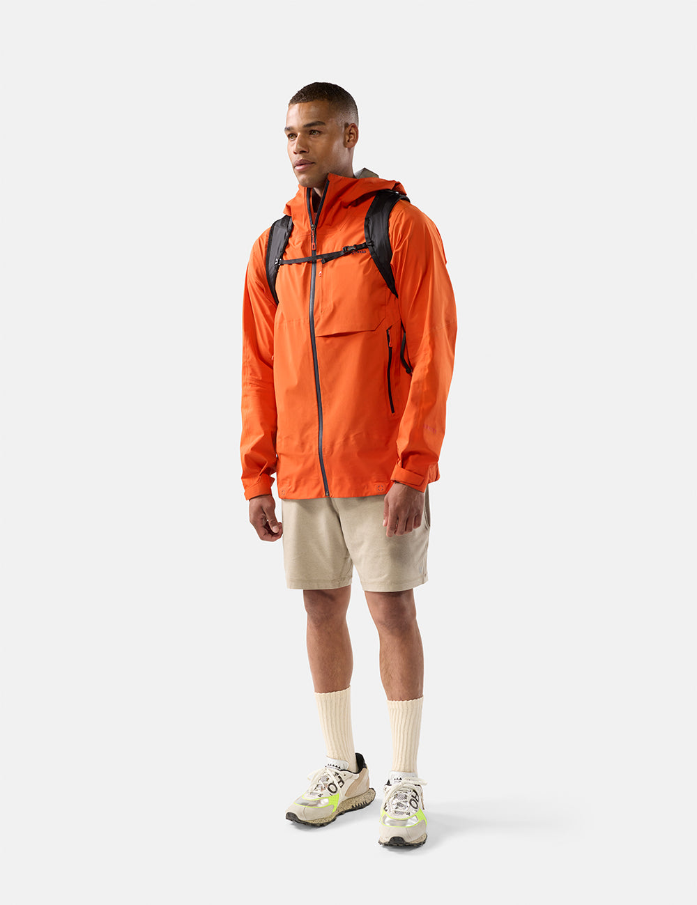 video of man in orange jacket wearing black backpack