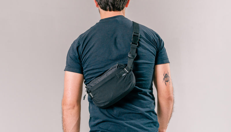 back view of man wearing black sling across his back