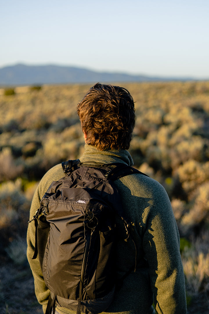 person wearing a black backpack while traveling outside