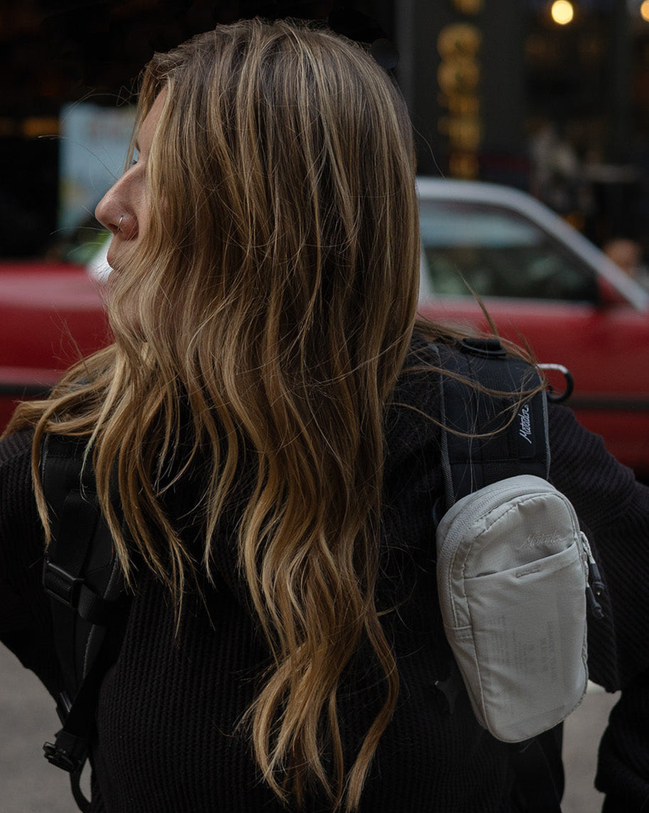 woman looking to the side with a speed stash on her backpack