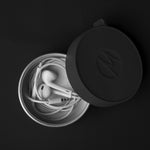 Canister with headphones inside on black background