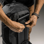 Man securing duffle to suitcase handle