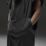 Close up of hands in charcoal poncho kangaroo pouch on gray background