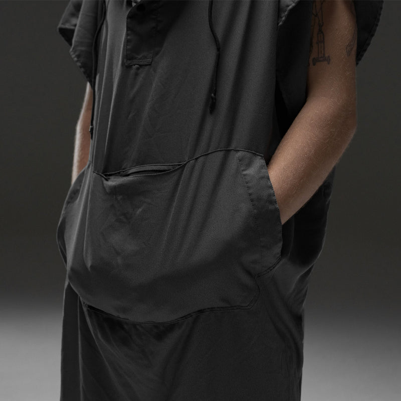 Close up of hands in charcoal poncho kangaroo pouch on gray background