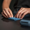 Woman on black background unrolling blue Droplet Stuff Sack
