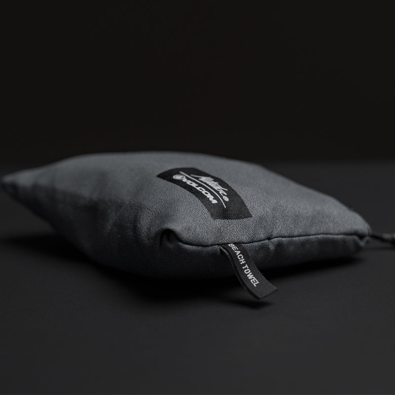 Packed up charcoal towel in pouch on black background