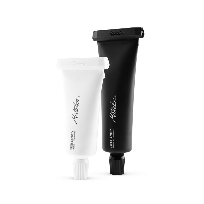 White and black toothpaste tubes standing upright on white background