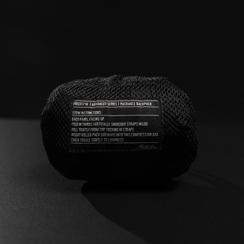 Packed down backpack pouch on black background