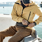Man on boat, unzipping hip pack