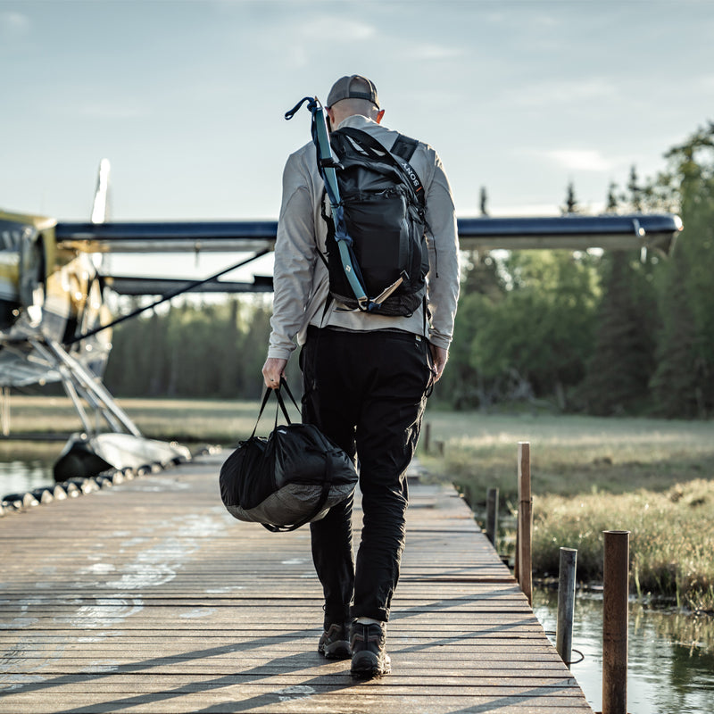 Man walking to sea plane with duffle in hand