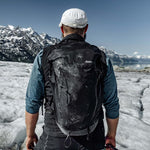Man wearing backpack on Alaskan glacier