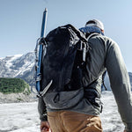Man wearing backpack with ice axe on Alaskan glacier 