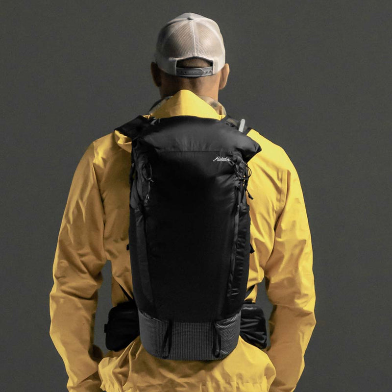 Man wearing backpack on black background