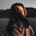 Woman at sunset lake, drying her face with the Charcoal NanoDry Trek Towel