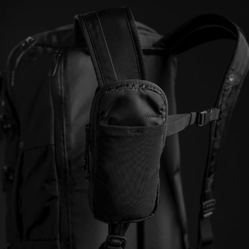 3/4 view of black backpack with speed stash attached to backpack strap