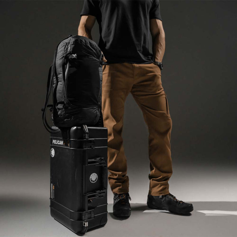 Man standing with hard suitcase and duffle sitting on top