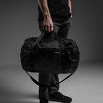 Man holding full duffel by carry handles 