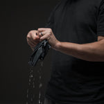 Man wringing out wet trek towel