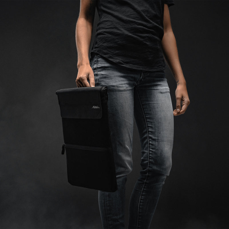 Person holding Laptop base layer by a carry handle 