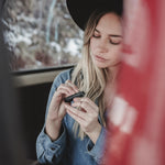 Woman taking earplugs out of black case